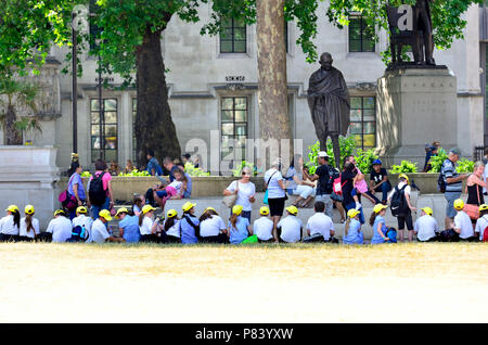 Los escolares de primaria en una excursión escolar en la Plaza del Parlamento, durante un período de tiempo, caliente y seco. Londres, Inglaterra, Reino Unido. Foto de stock