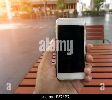 La mano del hombre muestra smartphone móvil en posición vertical, Boceto plantilla con fondo borroso - Sunset efecto de filtro