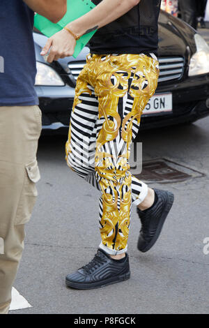 Milán - 16 de el hombre con pantalones de Versace con blanco y negro y decoraciones doradas antes de Marni Fashion Show, la Semana de la moda de Milán street style