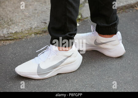Milán - 17 DE JUNIO: Hombre con Nike sneakers blanco antes de Prada Fashion Show, la Semana de la moda de Milán style el 17 de junio de 2018, en Milán de stock -