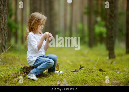 Adorable niña caminatas en el bosque en día de verano Foto de stock