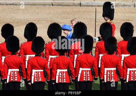 La Reina Isabel II de Gran Bretaña (L) y el Presidente de los Estados Unidos, Donald Trump (R) inspeccionar la guardia de honor del regimiento de Coldstream Guards formadas durante la ceremonia de bienvenida en el Castillo de Windsor en Windsor, al oeste de Londres, el 13 de julio de 2018, en el segundo día de visita en el Reino Unido del Triunfo. El Presidente de EEUU, Donald Trump lanzó un ataque contra el Primer Ministro extraordinario de mayo Teresa Brexit estrategia transatlántica, que sumieron a la relación 'especial' a un nuevo mínimo mientras se preparaban para reunirse el viernes en el segundo día de su agitado viaje a Gran Bretaña. / AFP PHOTO / Pool / Ben STANSALL Foto de stock