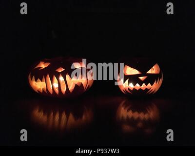 Scary Halloween calabazas aislado sobre un fondo negro. Miedo rostros resplandecientes trick or treat.