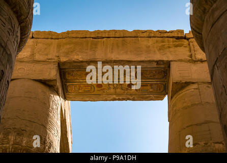 Mirando hacia coloridos jeroglíficos egipcios pintados en la parte superior de las columnas, gran sala hipóstila salen precinto de Amun Ra, Templo de Karnak. Luxor, Egipto, África
