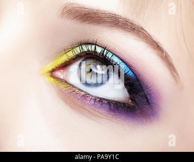  Closeup imagen macro de derechos femeninos con sombras de ojos violeta, azul y amarillo y maquillaje Fotografía de stock