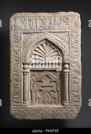 Lápida de al-Khatun Fátima bint Zahir al-Din. Dimensiones: H. 25 3/4 in. (65,4 cm) W. 17. (43,2 cm) wt. 83 libras (37,6 kg). Fecha: 11º-12º siglo. Aunque las piedras talladas de este tipo han sido identificados como marcadores graves, aspectos de su forma e inscripciones sugieren que se trata de un flat mihrab (nicho de oración). La piedra de versos del Corán y el Hadith (tradiciones del Profeta Muhammad) destacan la oración y hacer buenas obras, pero no mencionan el paraíso o la palabra "tumba", ambos de los cuales se encuentran en la mayoría de las lápidas. El nombre de la mujer que ordenó la piedra está tallado en la Foto de stock