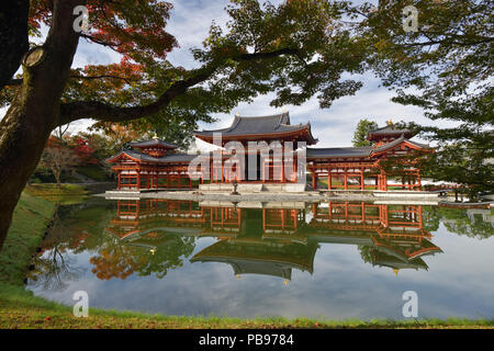 Tranquilo paisaje de otoño el Phoenix Hall, salón de amida templo Byodoin en Kojima isla de Tierra Pura Jodoshiki entei, estanque de jardín en un soleado