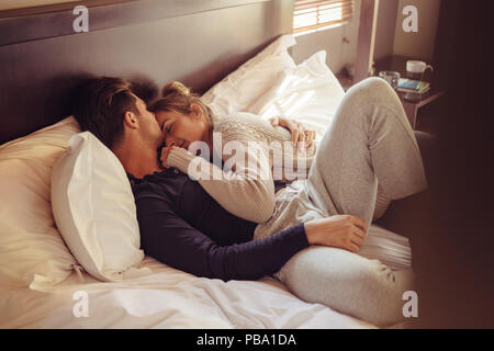 Pareja joven en la cama posando para su novio en ropa interior