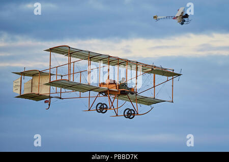 Un Bristol Boxkite réplica volando con un Avro Triplane réplica en el fondo contra un cielo nublado por la tarde Foto de stock