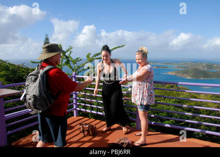 Hombre ayudando a dos mujeres jóvenes con fotografía, vacaciones Paradise Point, St Thomas, Caribe Foto de stock