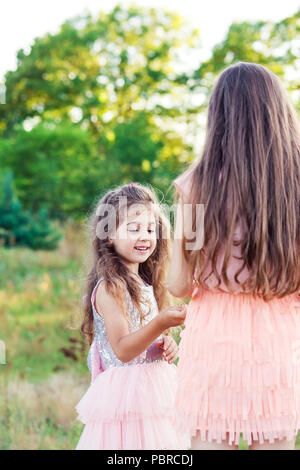 Retrato de dos niñas felices divirtiéndose y abrazar en un día soleado de verano