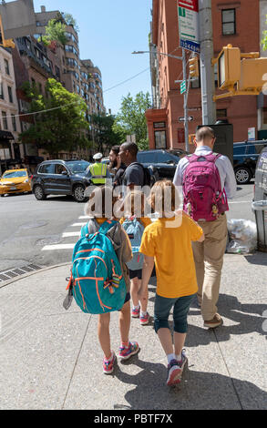 El hombre escolta de jóvenes estudiantes de la escuela a casa en Nueva York, EE.UU. Foto de stock