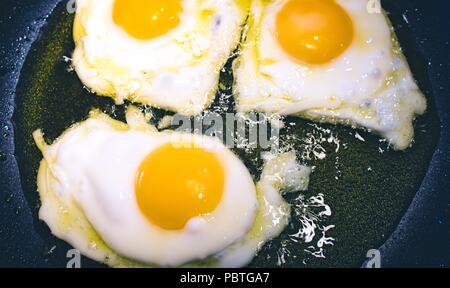 3 huevos fritos, freír en una sartén con aceite de oliva Foto de stock