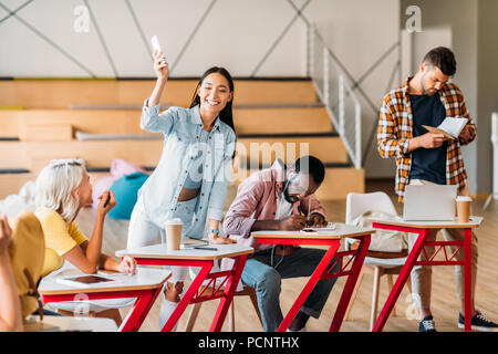 Felices los jóvenes estudiantes pasar tiempo juntos en la sala de conferencias