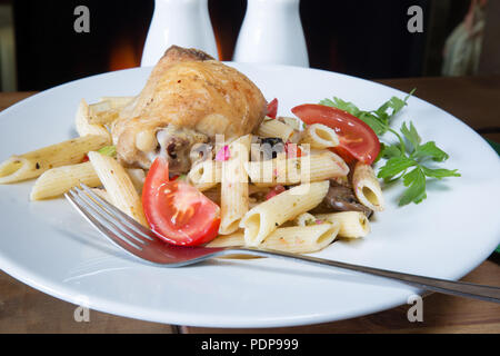 Una comidas de Pollo, Ajo Penne e infundida de muslo de pollo asado con pasta penne y el tomate, la cebolla y las setas