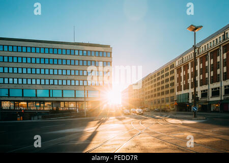 Helsinki, Finlandia - 11 de diciembre de 2016: Vista de Siltasaarenkatu Street. Mover los coches en la luz del sol del atardecer amanecer