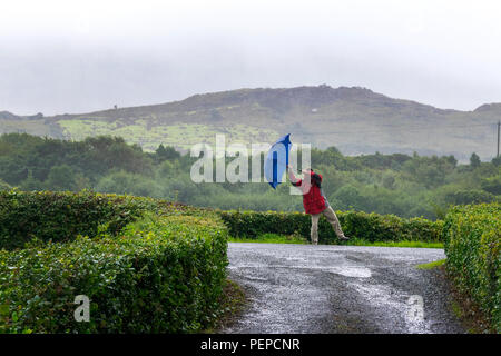 Ardara, Condado de Donegal, Irlanda clima. 17 de agosto de 2018. Un hombre luchas a lo largo de una carretera en un día de fuertes vientos y lluvias en Irlanda del Norte-oeste de costa. Crédito: Anna Hidalgo-Wayman/Alamy Live News Foto de stock