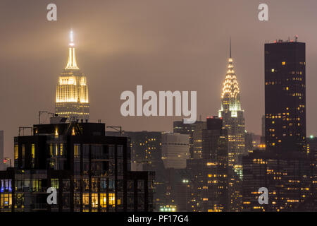 El Empire State Building y el Edificio Chrysler iluminado por la noche como se ve desde Long Island City, Queens, Nueva York.
