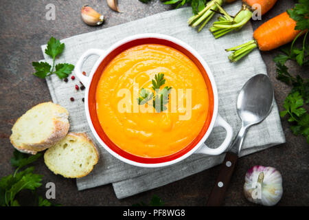 Sopa crema de calabaza zanahoria en mesa de piedra oscura. Vegetariana sopa de verduras. Vista desde arriba.