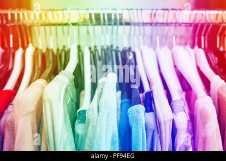 Colorida ropa de mujer en negro perchas de ropa de la tienda. Arco iris de colores. Foto de stock