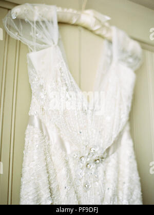 Close-up de blanco vestido nupcial con sequin detallando colgado en un armario Foto de stock