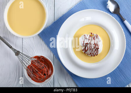 Una isla flotante o ÎLE FLOTTANTE, compuesto de merengue flotando sobre  creme anglaise y rociados con ganache de chocolate, la receta auténtica,  ingredien Fotografía de stock - Alamy