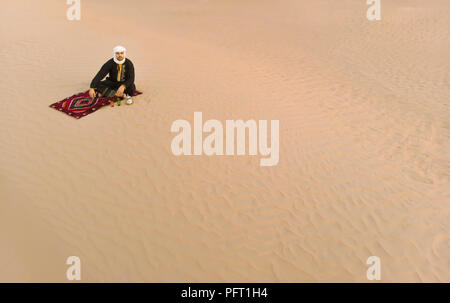 Hombre tuareg beber té en un desierto Foto de stock