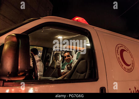 Belén, Palestina, 23 de julio de 2014: Un paramédico está sentado en la ambulancia de la media luna roja, a la espera de ser llamados a víctimas en Belén durante la noche Foto de stock