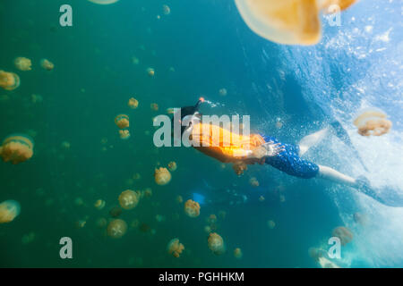Fotografía submarina de buceo con niños sin aguijón endémica medusas en el lago en el Palau.