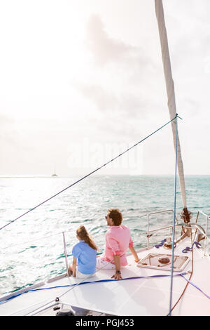Padre e hija a bordo del yate de vela disfrutando del atardecer Foto de stock