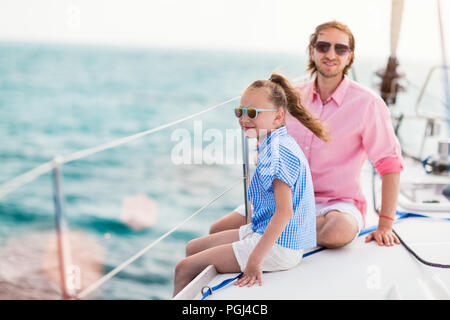 Familia de padre e hija a bordo del yate de vela disfrutando del atardecer Foto de stock