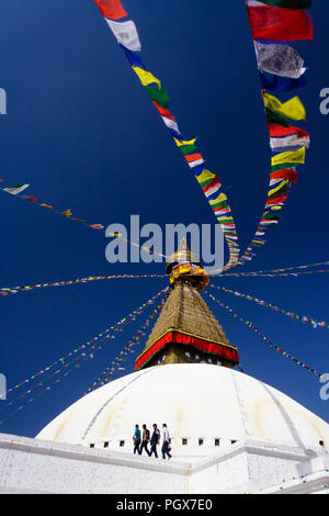 Bodnath, Katmandú, Nepal, Bagmati : Cuatro hombres caminan alrededor de la Gran Stupa de Bodnath, el más grande de Asia y uno de los más grandes en el mundo. Foto de stock