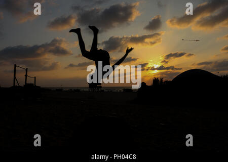 Dos jóvenes palestinos, Fathi El Masry, de 16 años, y Mohamed El Sakany, 15, practicar el deporte del Parkour en la playa de la ciudad de Gaza. La playa de Gaza es uno de los pocos lugares de descanso para los gacenses, que han vivido bajo bloqueo israelí desde 2007. 28 Aug, 2018. Parkour es una disciplina física de escalar, saltar, correr y equilibrio que requiere la formación del cuerpo y la mente en el desarrollo de fuerza, agilidad, coordinación, sino también de la auto-disciplina y determinación de crédito: Ahmad Hasaballah/IMAGESLIVE/Zuma alambre/Alamy Live News Foto de stock