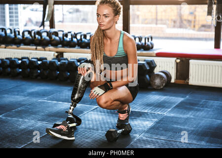 Retrato de fitness sportswoman discapacitados en chándal ejercicios de crossfit y levantamiento pesa en gimnasio Fotografía de stock - Alamy