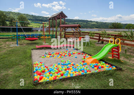 Parque infantil con toboganes y bolas de colores en el exterior arena  Fotografía de stock - Alamy