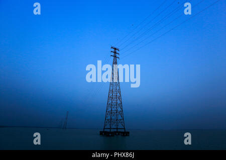 Los postes de la electricidad del Sistema Interconectado Nacional en el río Meghna en Bhola, Bangladesh Foto de stock