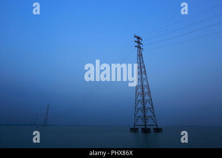 Los postes de la electricidad del Sistema Interconectado Nacional en el río Meghna en Bhola, Bangladesh Foto de stock