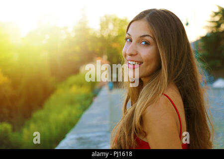 Retrato de feliz mujer sonriente permanente sobre el cuadrado en el soleado día de primavera o verano fuera, linda mujer sonriente al contemplaros, atractivo joven Foto de stock