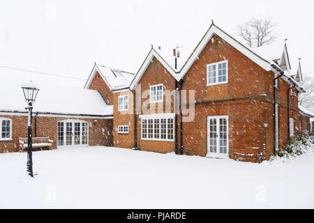 Una tradición victoriana Coach house cubierto de nieve en invierno. Buckingham, Reino Unido Foto de stock