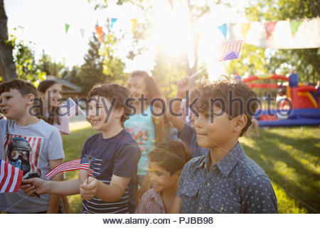 Los niños agitando banderas americanas en el 4º de julio de barrio de verano BLOCK PARTY en sunny park