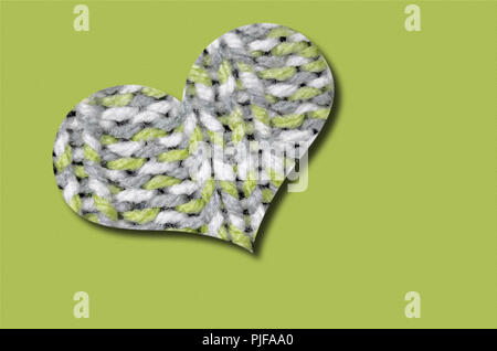 Tejida de corazón, luz verde, gris y blanco, aislado sobre fondo verde claro Foto de stock