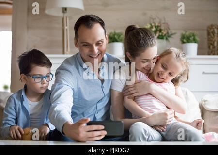 Padre haciendo de selfie sonriente y feliz familia de cuatro