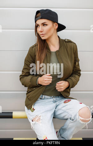 Hermosa mujer joven con una gorra de béisbol en una chaqueta