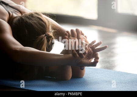 Joven mujer deportiva haciendo ejercicio paschimottanasana, cerrar Foto de stock