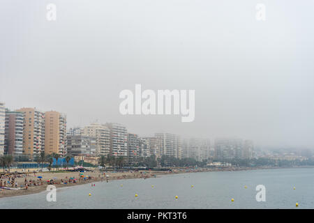El edificio a lo largo de la costa en la playa de La Malagueta cubierto por niebla en Málaga, España, Europa en una mañana neblinosa Foto de stock