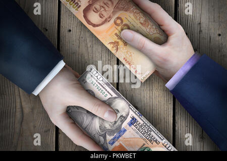 Dos billetes de moneda fiat intercambiados por dos personas de negocios como parte de una transacción de negocios. Foto de stock