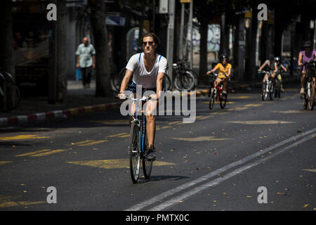 Tel Aviv, Israel. 19 Sep, 2018. 19 de septiembre de 2018, Israel, Tel Aviv: Una mujer monta su bicicleta en una carretera vacía durante la festividad judía de Yom Kippur, en Tel Aviv, Israel, 19 de septiembre de 2018. Yom Kipur, también conocido como el día de la Expiación, es el día más sagrado del calendario judío, en el que el pueblo judío realizar ayuno y oración intensa. Crédito: Ilia Yefimovich/dpa/Alamy Live News Foto de stock