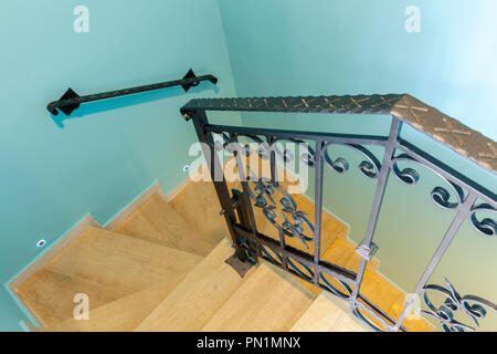 Buscando un hogar escalera con pasamanos de hierro forjado, barandas de  madera y pisos de madera en toda la casa Fotografía de stock - Alamy