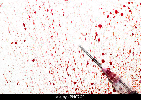 Una jeringa con sangre rociada sobre un fondo blanco.