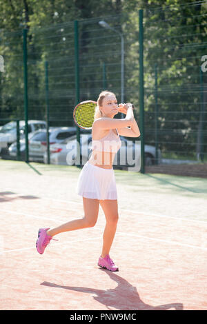 Jugador de tenis femenino hermoso sirviendo outdoor Foto de stock